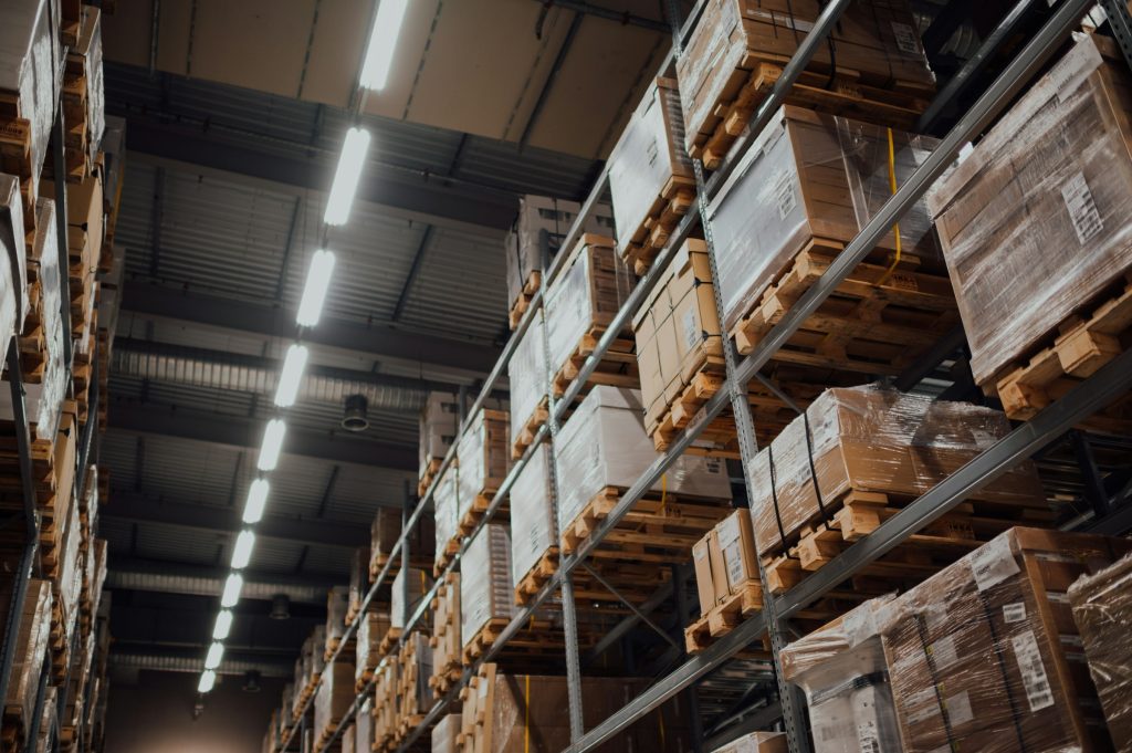 An image of brown cardboard boxes on white metal racks in a warehouse.