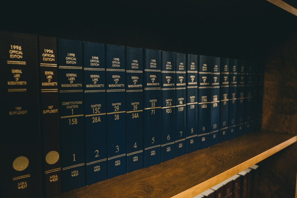 Blue law books on a brown wooden shelf